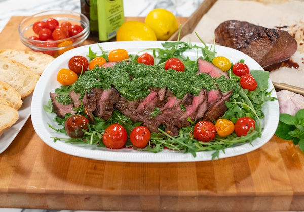 Sliced grilled tri-tip over arugula with chimichurri and blistered tomatoes