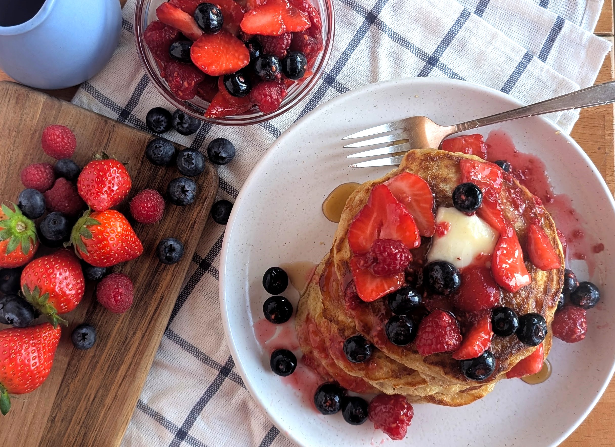 Stack of buttermilk pancakes topped with Island berries and maple syrup
